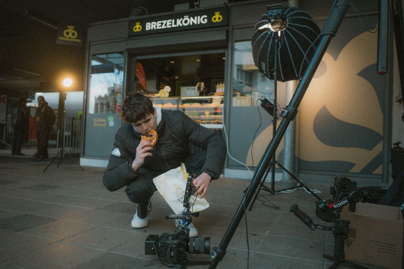 Janis Chatelain beisst am Set von Brezelkönig in eine Brezel