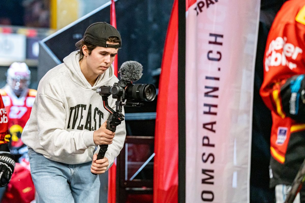 Janis Chatelain filmt mit Gimbal am Spielfeldrand eines Spiels des SC Bern